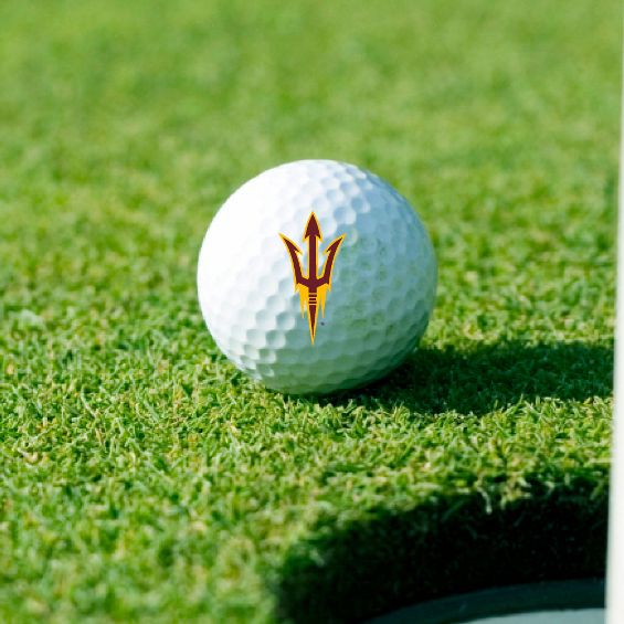 ASU white golfball on grass with pitchfork in maroon and gold