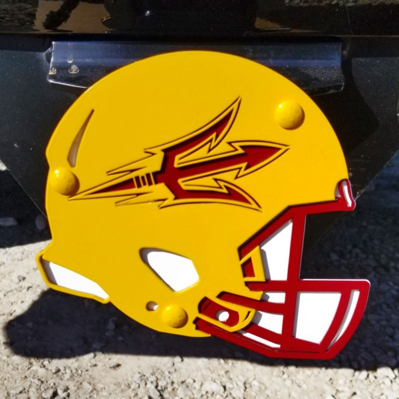 ASU gold, maroon, and white football helmet hitch cover with a pitchfork carved on the side
