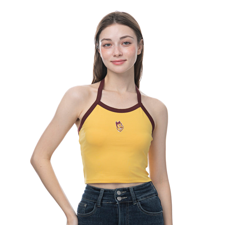 A young woman modeling a yellow ribbed halter crop top with dark brown trim and a small graphic on the chest, paired with dark blue jeans against a solid white background.