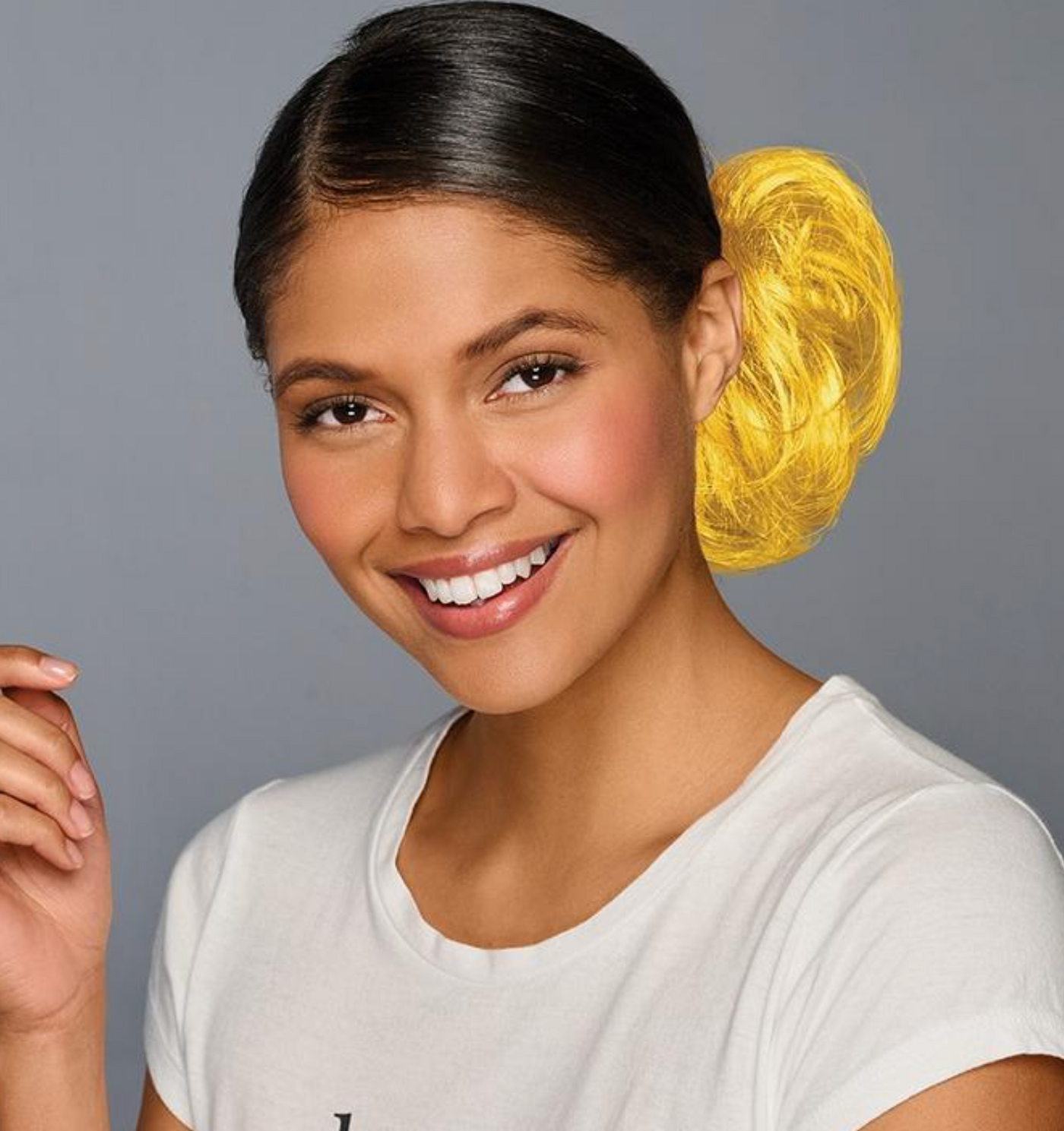 Woman with a yellow hair product on a gray background