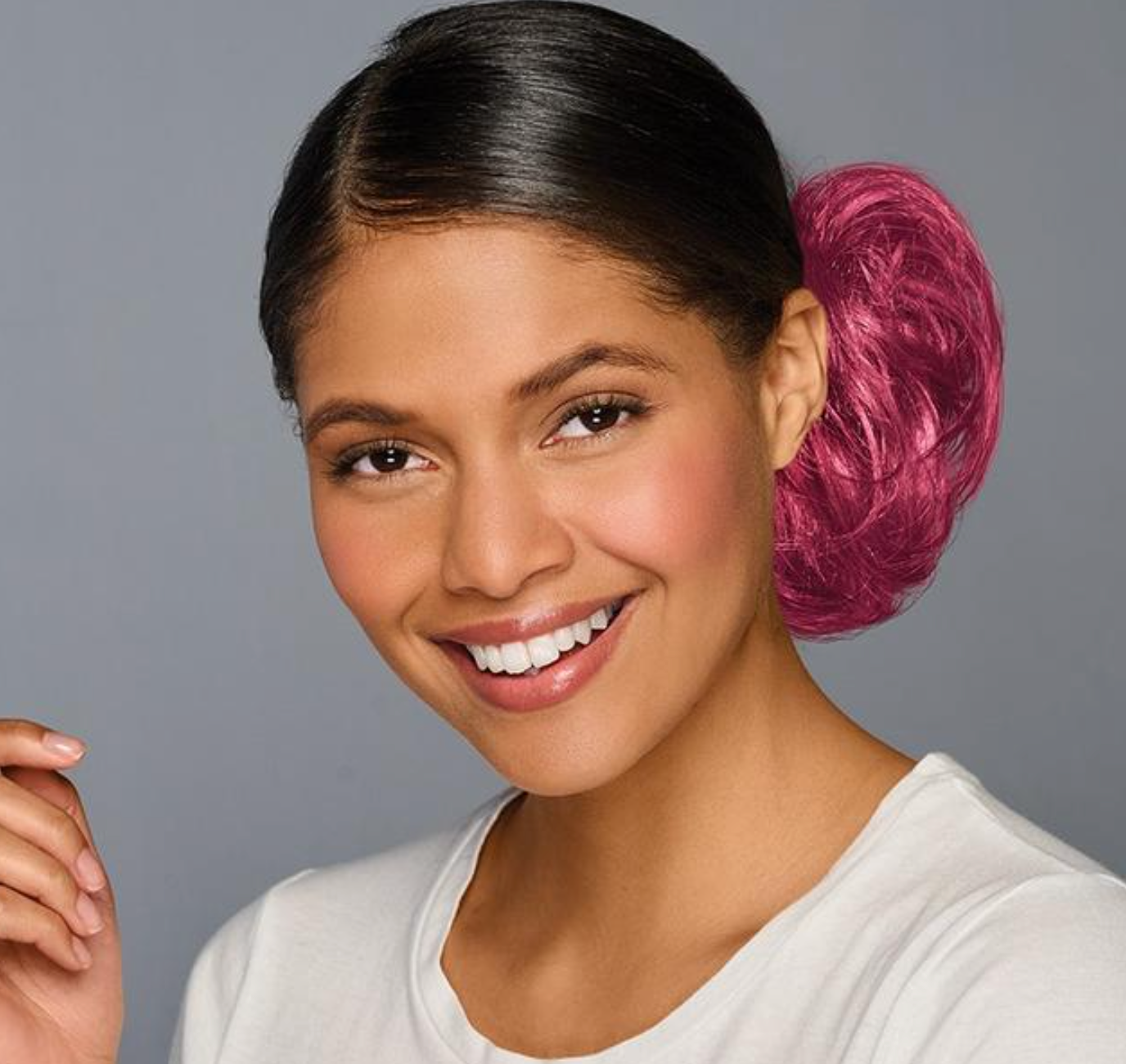 Woman with a maroon hair bun against a gray background