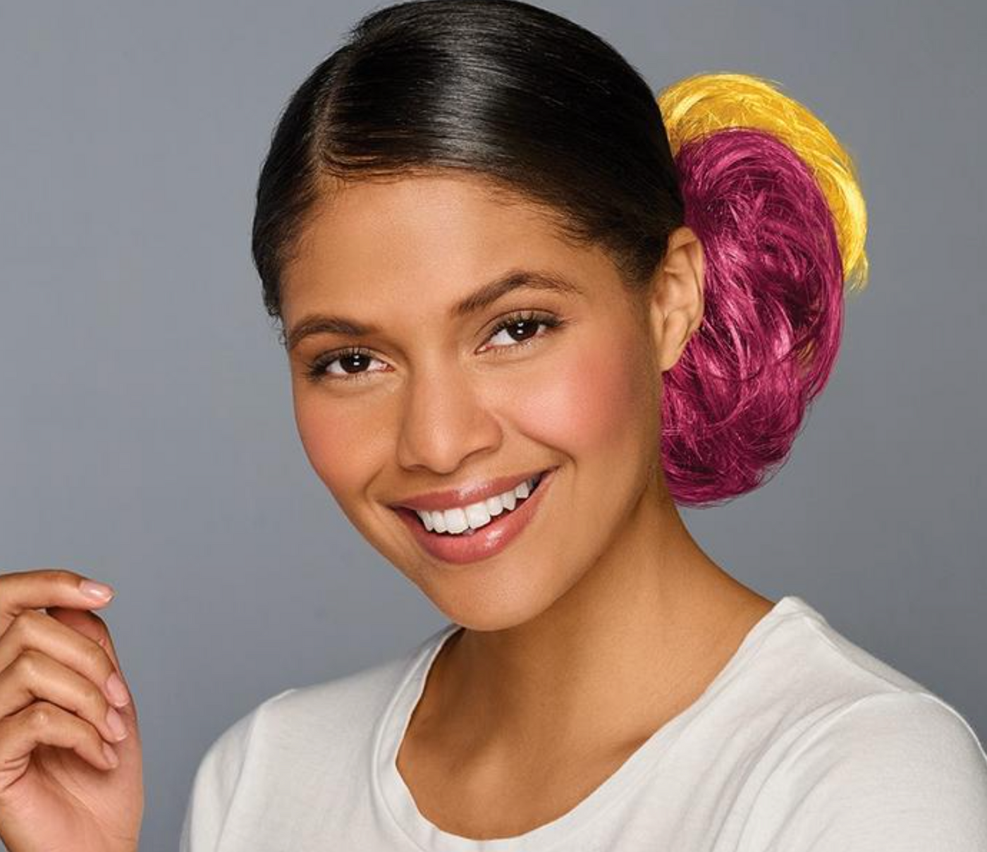 Woman with colorful hair extensions on a gray background