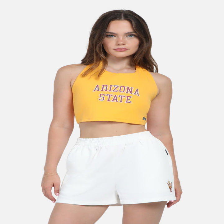 Model wearing cropped ASU halter top in gold. 