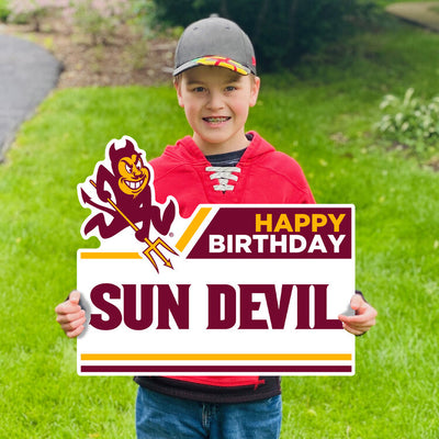 Boy holding ASU lawn sign in front yard with Sparky and 'Happy Birthday Sun Devil' lettering