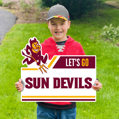 Boy holding ASU lawn sign in grass with Sparky and 'Let's Go Sun Devils' lettering