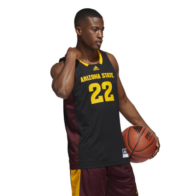 Model wearing ASU black Adidas basketball jersey with 'Arizona State' letters above '22' and gold features and maroon side panels