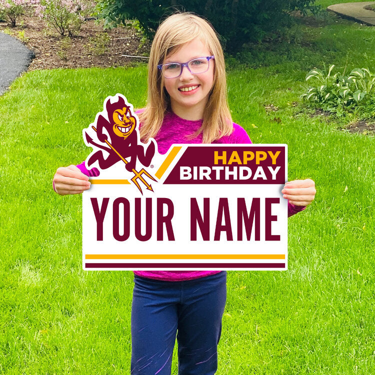 Girl holding lawn sign in yard saying 'Happy Birthday, Your Name' with Sparky in the right upper corner